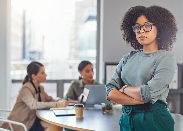 A female African employee looking serious in a boardroom setting negotiating her retrenchment package.